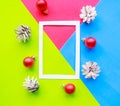 Photo frame and Christmas decorations on bright blue, green and pink geometric paper background. Flat lay, top view, copy space. Royalty Free Stock Photo