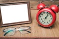 Photo frame with copy space and alarm clock and glasses.