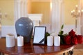 Photo frame, cremation urn and candles in church Royalty Free Stock Photo