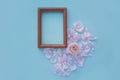 Photo frame heart of light pink petals on a light blue textural background with a flower in the center Royalty Free Stock Photo