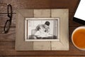 Photo frame, lemon tea and mobile phone on wooden plank