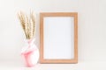 Photo frame mock up, bouquet of dry wheat spikelets in pink vase