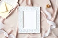 Photo frame mockup and female accessories on fabric background. Flat lay, top view, copy space. Boho style Royalty Free Stock Photo