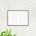 Photo frame mockup on white wall. Poster mockup. Clean, modern, minimal frame. Minimalist background. Blank picture frame mockup. Royalty Free Stock Photo