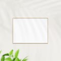 Photo frame mockup on white wall. Poster mockup. Clean, modern, minimal frame. Minimalist background. Blank picture frame mockup. Royalty Free Stock Photo
