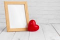 Photo frame and red heart on white wood table with copy sapce, love concept