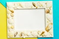 Photo frame with shells on turquoise and yellow color paper texture background. The concept of a summer vacation.  Summer Flatlay Royalty Free Stock Photo
