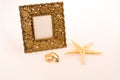 Photo frame, starfish and rings on white background Royalty Free Stock Photo