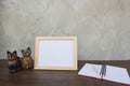 Photo Frame on a wooden table and book and toy cat Royalty Free Stock Photo