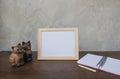 Photo Frame on a wooden table and book and toy cat Royalty Free Stock Photo