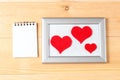 Photo frames, blank card and handmade hearts over wooden background Royalty Free Stock Photo