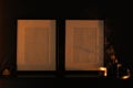 Two empty photo frames on a shelf on a dark background. mocap. modern interior in dark colors. close-up of candle and photo frame