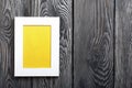 Photo frames of white color with a yellow field. It is located on the background of brushed pine boards painted in black and white