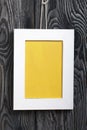 Photo frames of white color with a yellow field. It is located on the background of brushed pine boards painted in black and white