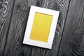 Photo frames of white color with a yellow field. It is located on the background of brushed pine boards painted in black and white