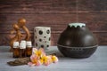 Brown essential oil diffuser with frangipani flowers, candle and small wooden love statue