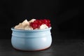Photo of fresh natural cottage cheese with red currant in a blue ceramic bowl on the black stone plate. Organic eco healthy meal, Royalty Free Stock Photo