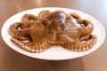 Photo of a fresh octopus on a white platter ready to cook