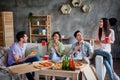 Photo of friendly cheerful people sit couch speak laugh eat pizza drink beer loft interior house indoors Royalty Free Stock Photo