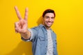 Photo of friendly cool man dressed jeans shirt showing you v-sign isolated yellow color background