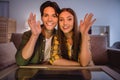 Photo of friendly cute young couple wear casual shirts smiling sitting couch waving arms talking modern device indoors Royalty Free Stock Photo