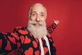 Photo of friendly hospitable old man make selfie hand show empty space wear heart print suit isolated red background