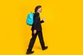 Photo of friendly little schoolboy walk wave palm wear backpack black uniform shoes isolated yellow color background