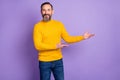 Photo of friendly man hands demonstrate invitation sign wear yellow sweater jeans isolated purple background