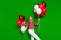 Photo of friendly positive teen dressed print shirt hold palms helium balloons celebrate valentine day isolated on green Royalty Free Stock Photo