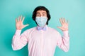 Photo of frightened man dressed pink shirt medical mask two arms up isolated turquoise color background