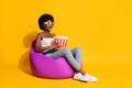 Photo of frightened scared young woman wear casual clothes 3d eyewear sitting bean bag holding popcorn box isolated