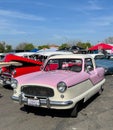 Photo of a front view of a Pink and white Classic Nash Car