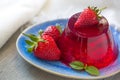 Photo of fruit jelly with fresh strawberry. Healthy food. Strawberry jelly on white plate. Summer dessert with fruit