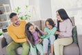 Photo of full big family four members sit couch enjoy tickling wear colorful sweater trousers in living room indoors Royalty Free Stock Photo