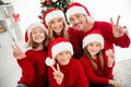 Photo of full big happy family five people gathering three small kids show v-sign smile wear x-mas headwear red jumper Royalty Free Stock Photo