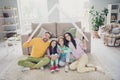 Photo of full family four members cuddle mom dad hold paper roof sit floor smile camera wear colorful jumper in living Royalty Free Stock Photo