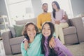 Photo of full family four members sit couch carpet two small kids twins embrace wear colorful pullover trousers in Royalty Free Stock Photo