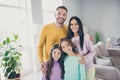 Photo of full family four members two little children embrace shiny smile wear colorful pullover in living room indoors Royalty Free Stock Photo