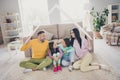 Photo of full family four members two small kids mom dad hold paper roof sit carpet wear colorful pullover in living Royalty Free Stock Photo