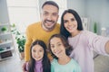 Photo of full family four people mommy take selfie hug beaming smile wear colorful sweater in living room indoors