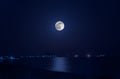 Photo of full moon in black sky above the sea with reflection Royalty Free Stock Photo