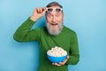 Photo of funky aged man wear spectacles enjoy cinema series hold pop corn plate isolated blue color background