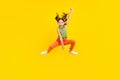 Photo of funky charming preteen girl dressed green top jumping high riding horse throwing lasso smiling isolated yellow Royalty Free Stock Photo