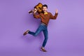 Photo of funky crazy musician guy hold guitar dance wear bow tie plaid shirt jeans shoes isolated purple background