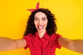 Photo of funky crazy young pretty woman make selfie funny face camera isolated on yellow color background