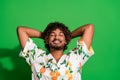 Photo of funky dreamy arabian man wear print shirt closed eyes arms behind head isolated green color background Royalty Free Stock Photo