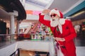 Photo of funky fashion trendy santa claus looking far away smiling indoors boutique store