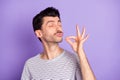 Photo of funky funny dreamy man with closed eyes trying delicious tasty food meal isolated on violet color background Royalty Free Stock Photo