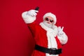 Photo of funky handsome santa claus wear red costume hat eyewear showing v-sign tacking selfie lips pouted isolated red