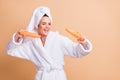 Photo of funky happy young lady hold bottles dance wear bathroom turban robe isolated on pastel beige color background Royalty Free Stock Photo